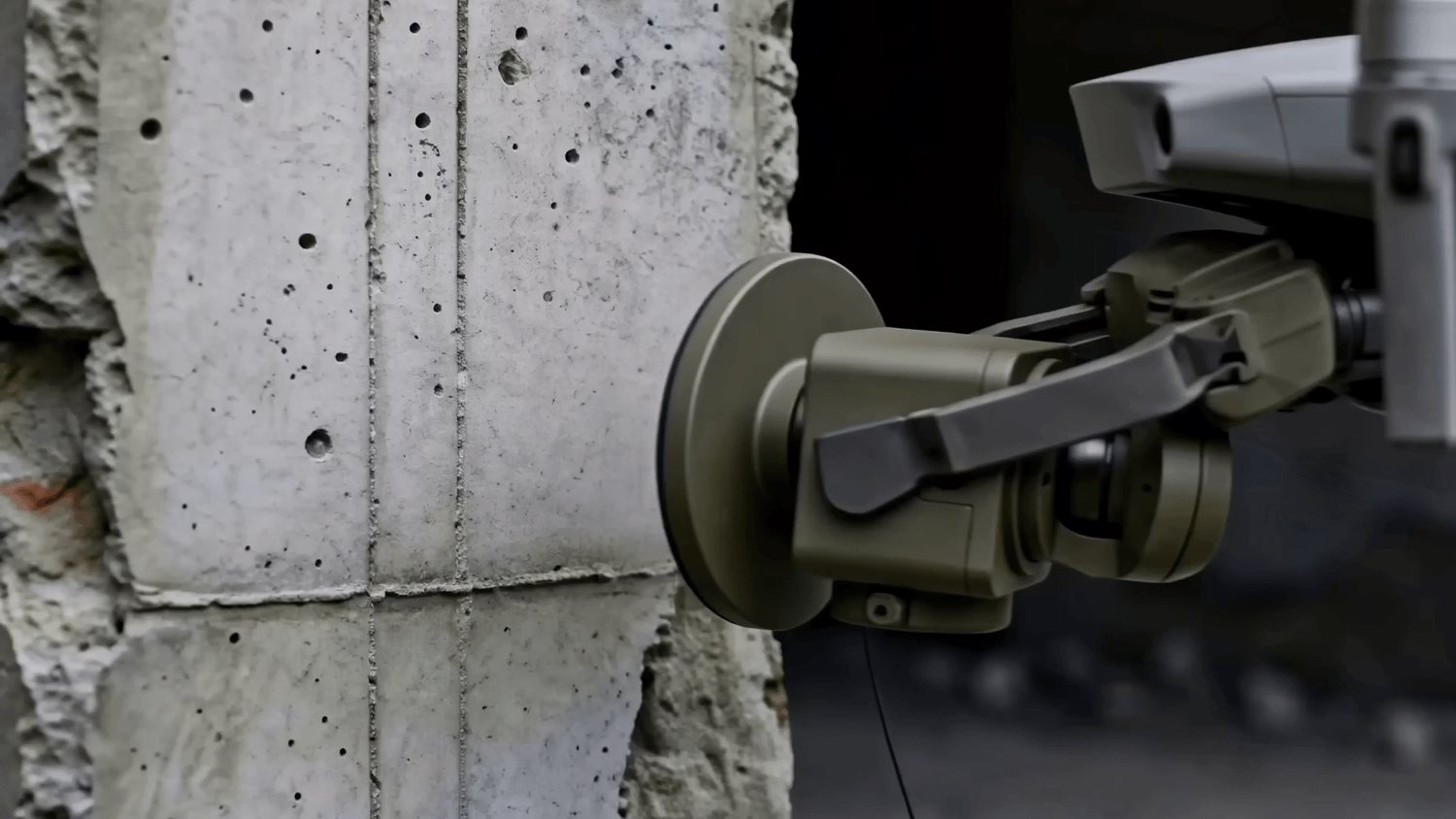 The drone presses the node's pad against a concrete wall to attach it.